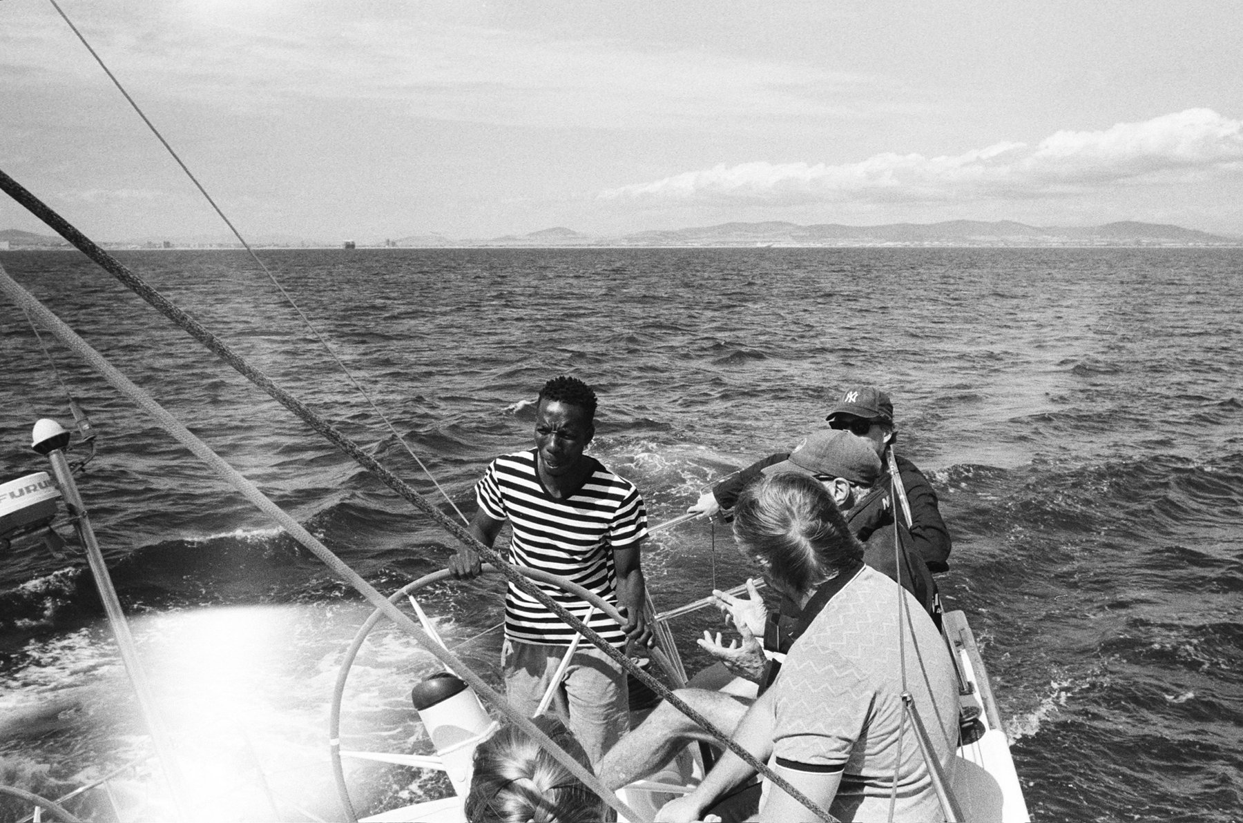 The skipper at Warrior's wheel with the Cape Town coast behind